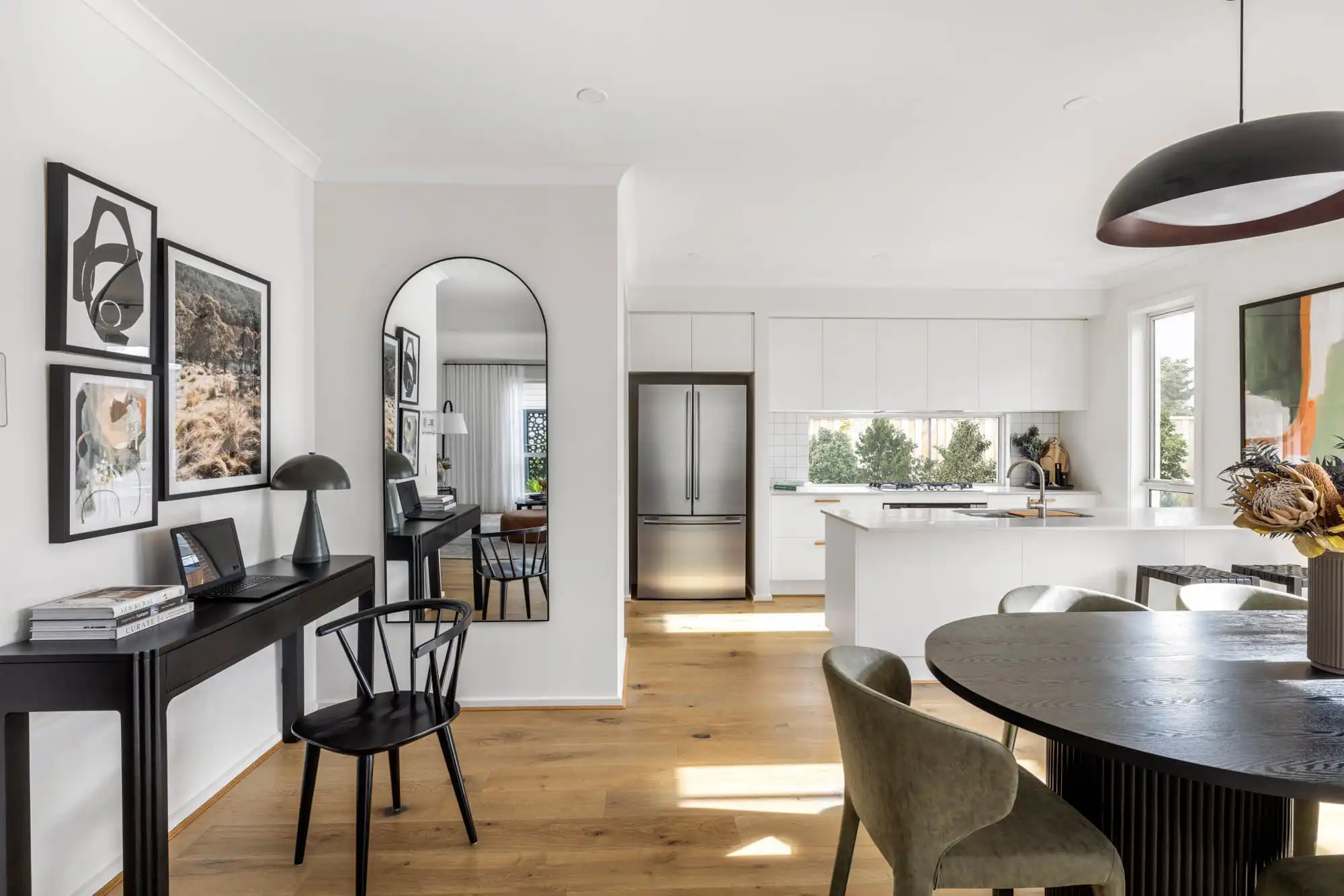 Interior image of a modern living area with a study space and an open-concept kitchen facing the dinning area as part of Simonds Nowra 26 home design.