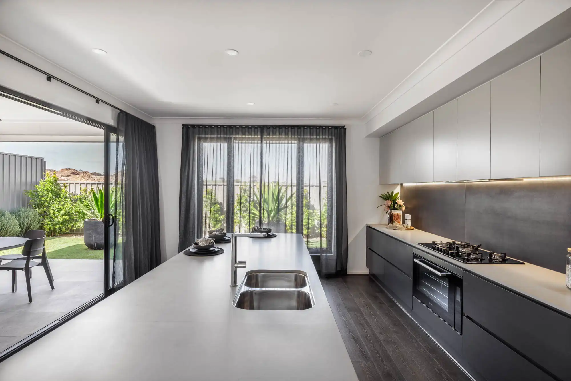 The Berwick 38 Seaford heights sliding door that opens out from the kitchen to alfresco with dark timber finishings
