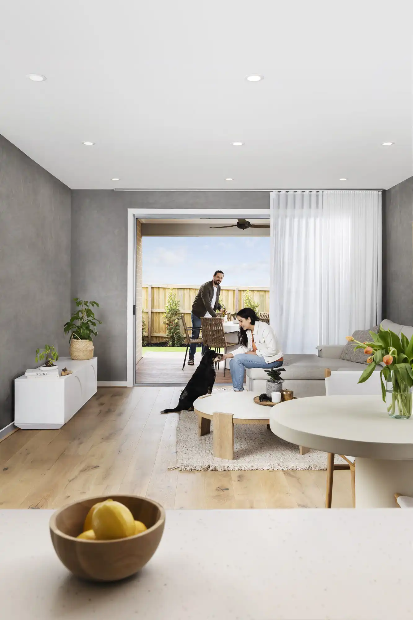 Customers in their new Simonds home with the doors opening out onto the alfresco