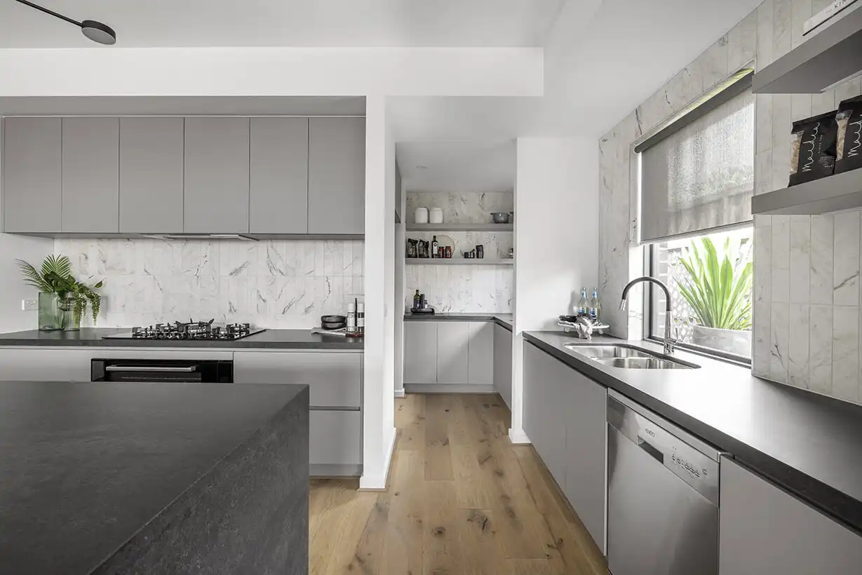 subway marble splashback balanced with a dark stone island bench with grey neutral palettes at the berrima 28