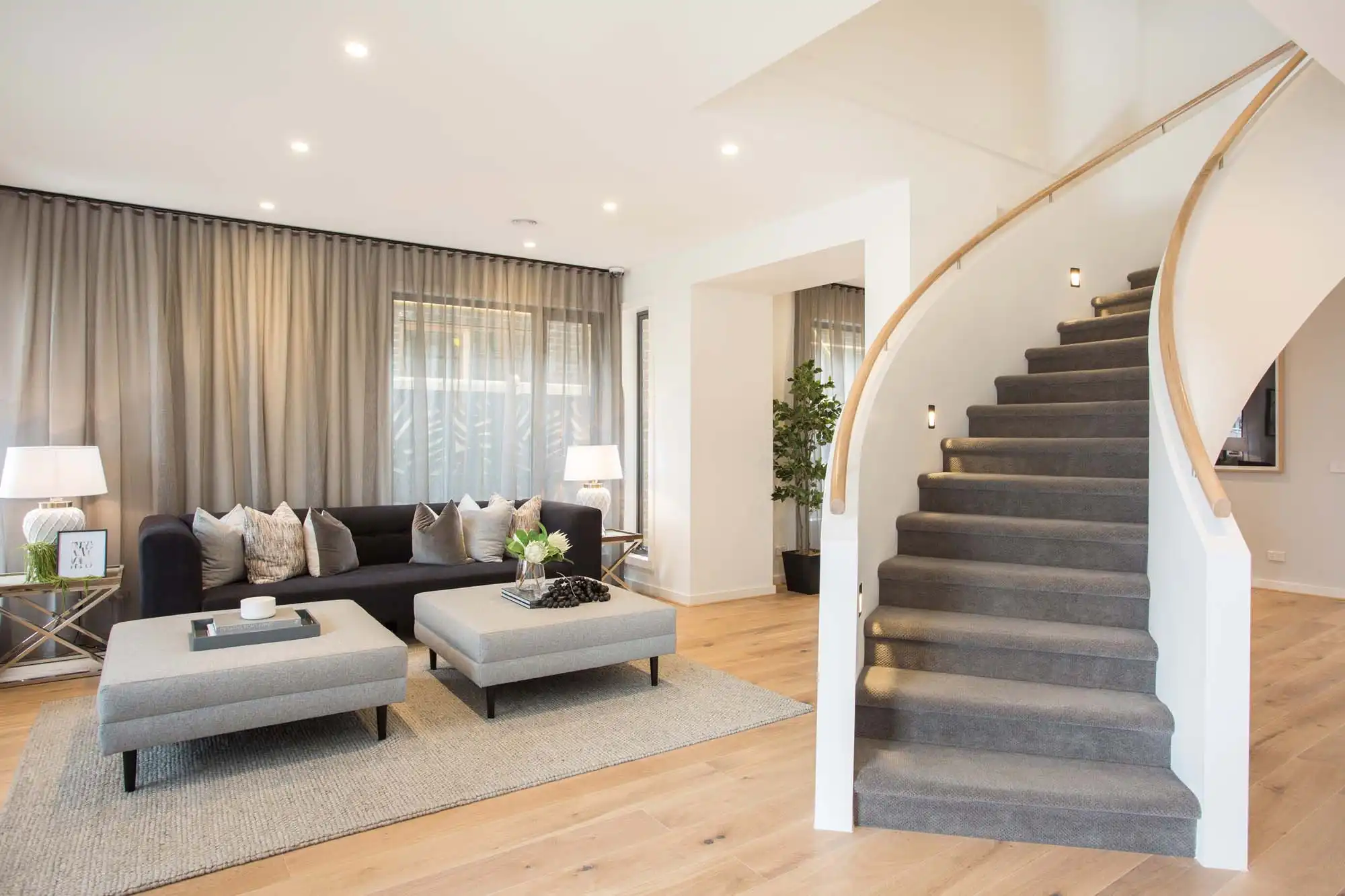 spiral staircase with carpet and timber railing wrapped into the living room including floor to ceiling curtains at the castlemine 41