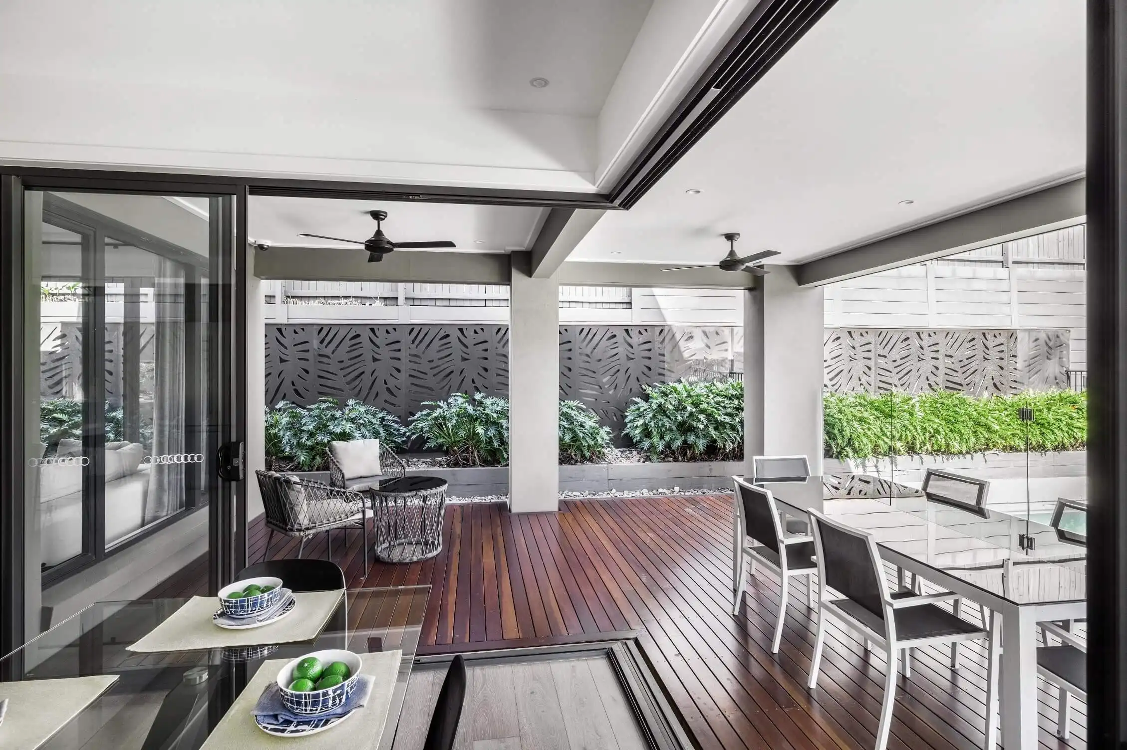 open living and kitchen with bifold doors opening up to the alfresco with timber decking surrounded at colston 26