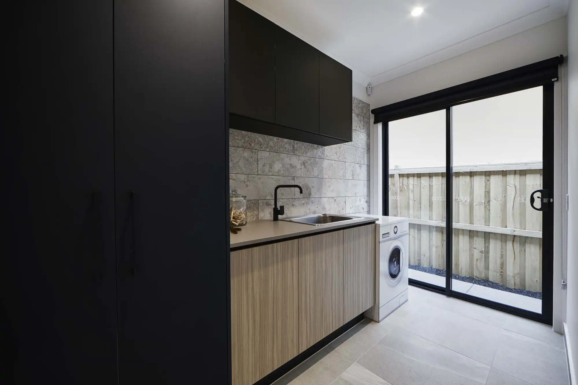 staggered stone tiling design and wood cabinetry feature in this dromana 28 laundry