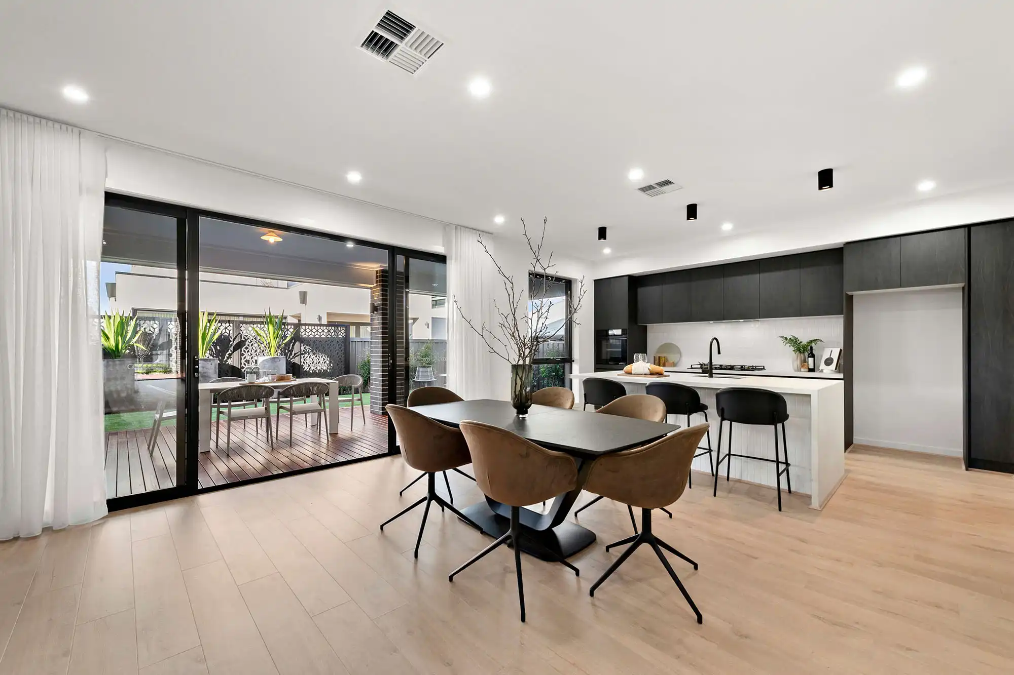 floor to ceiling curtains with solid dark wood dining table and light timber flooring with and overdue of the dining space