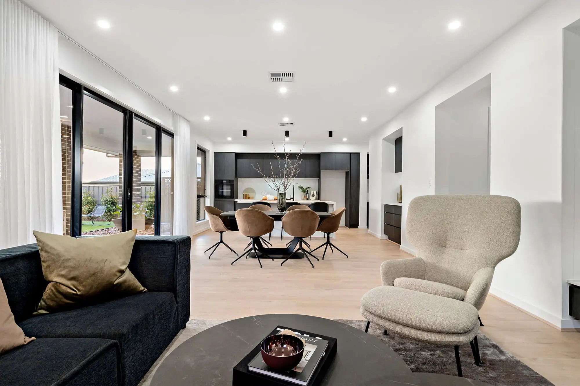 a mix of contemporary classic pieces in varying shades of brown throughout the open living space