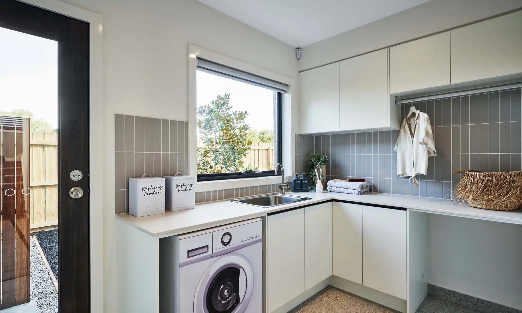 grey stacked vertical tiling mixed with stone flooring in laundry at ironbark 37