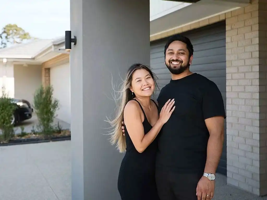 A photograph of the couple, Lauren and David, smiling in front of the closed garage.