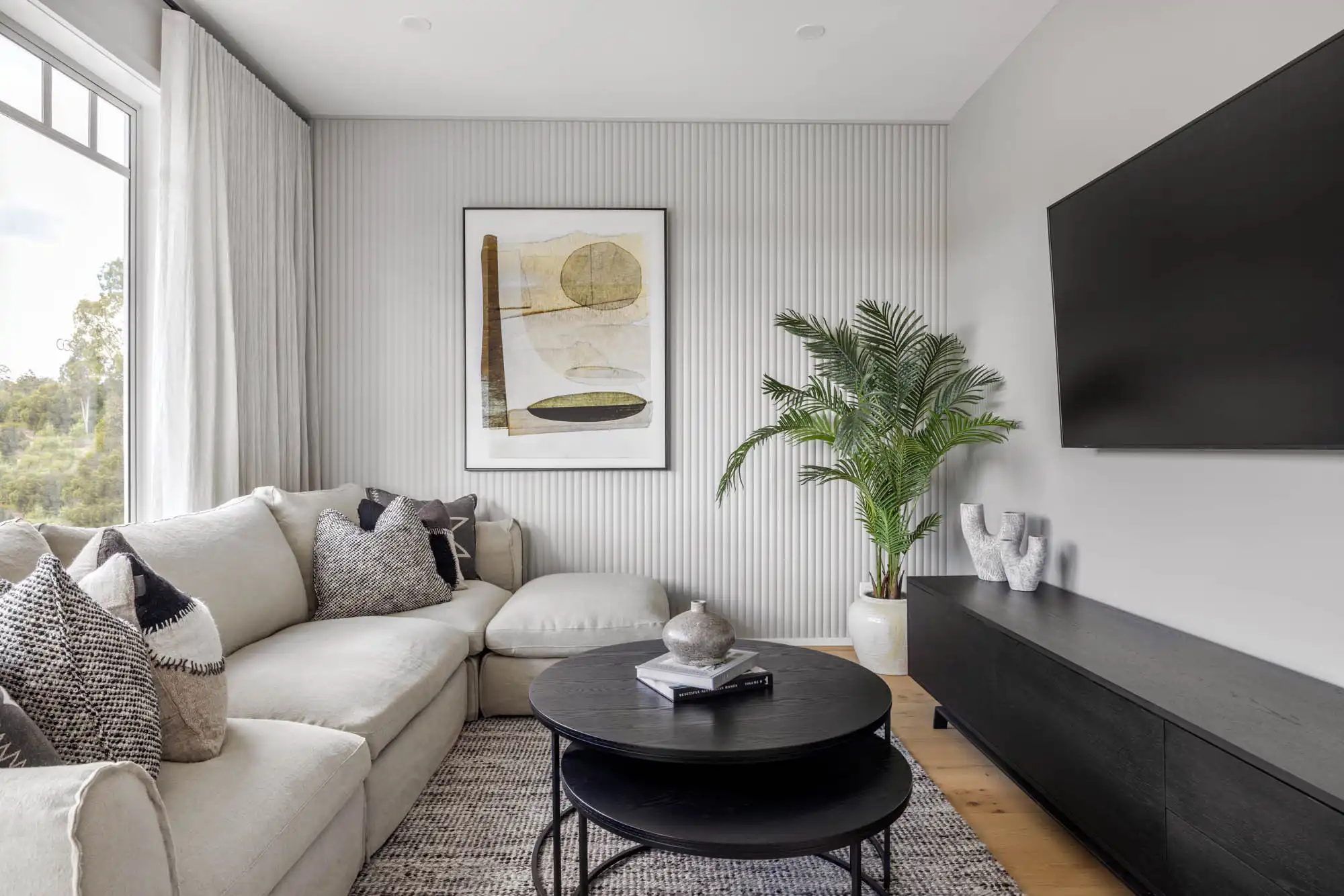 Comfortable living with wooden cladding as a featured wall with indoor plants to brighten up the space at riverway 26