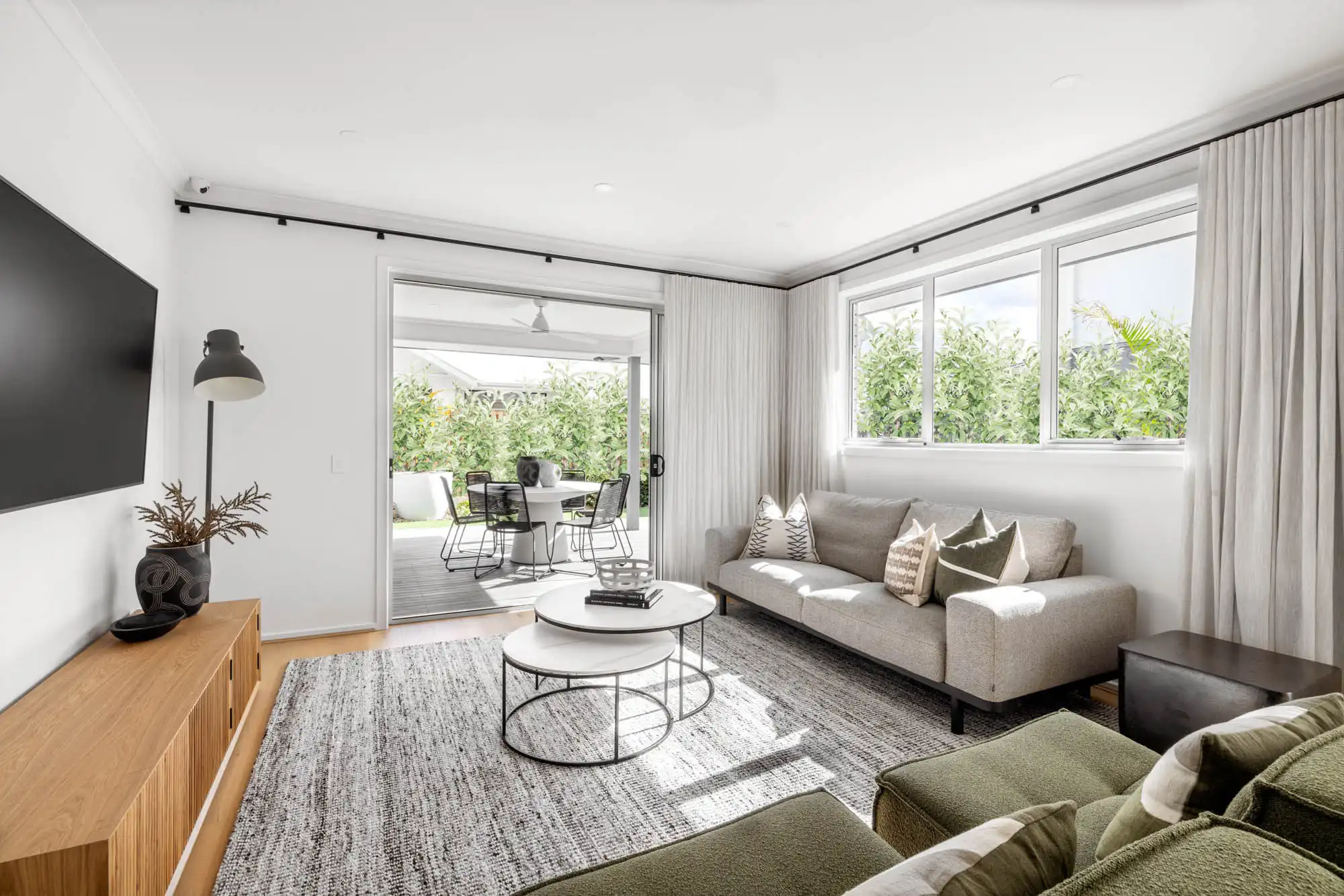 floor to ceiling curtains in the living room that connects to the backyard alfresco at riverway 26