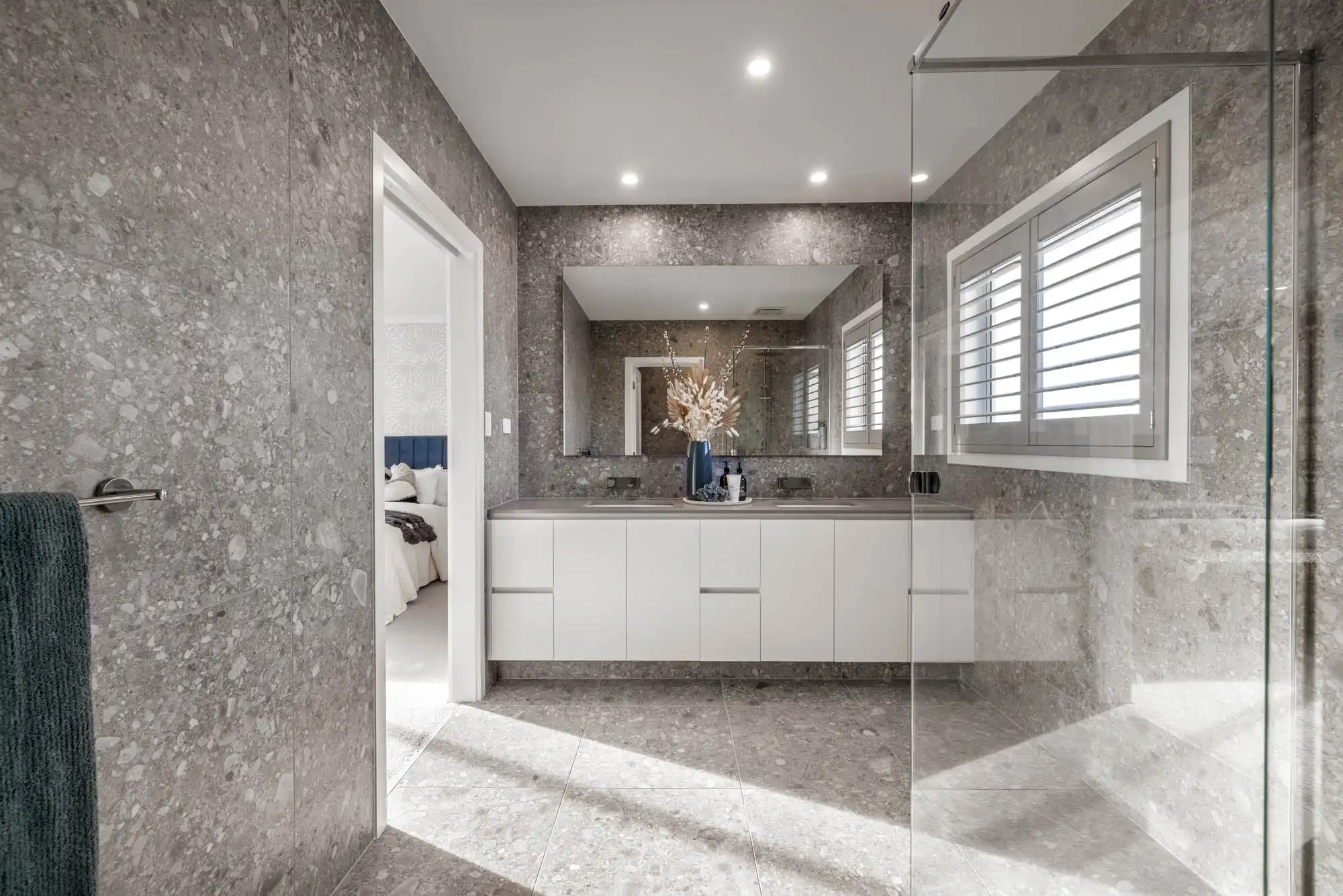 An interior image of a open concept bathroom with a double sink vanity as part of Simonds Travertine 31.