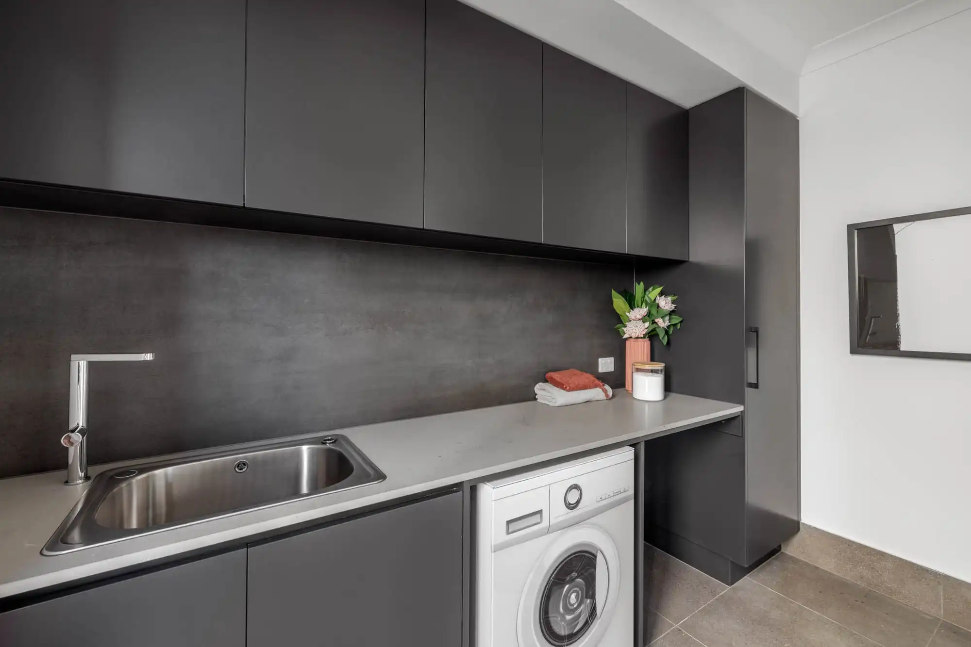 matte black laundry splash back with neutral flooring to brighten up the space at berwick 38