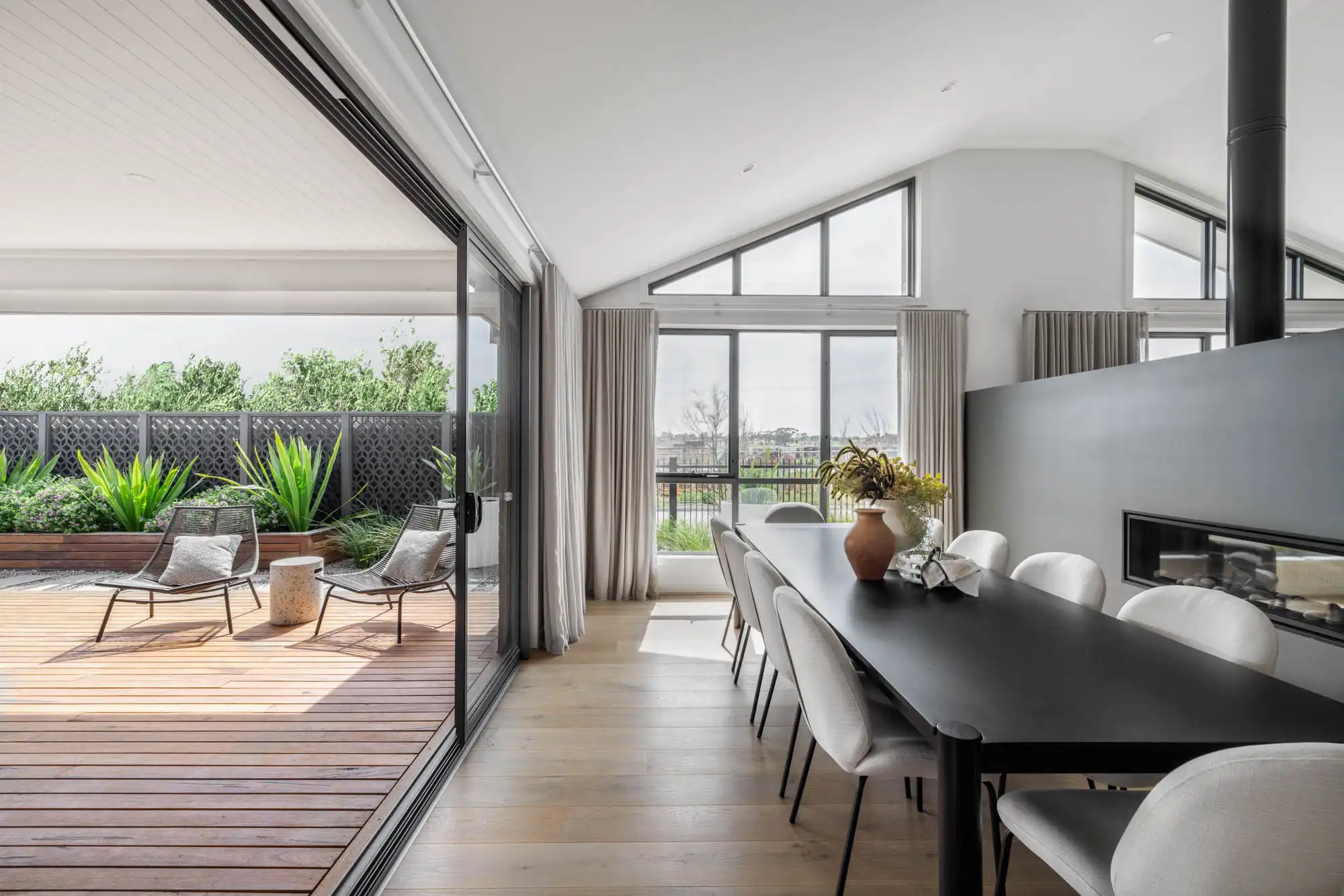 An image of an open living plan with the dinning table facing an alfresco setting with wooden floor as part of Simonds Hampstead 32.