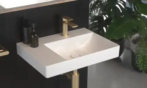 powder room basin with brass faucet for glow and warmth against a black back splash