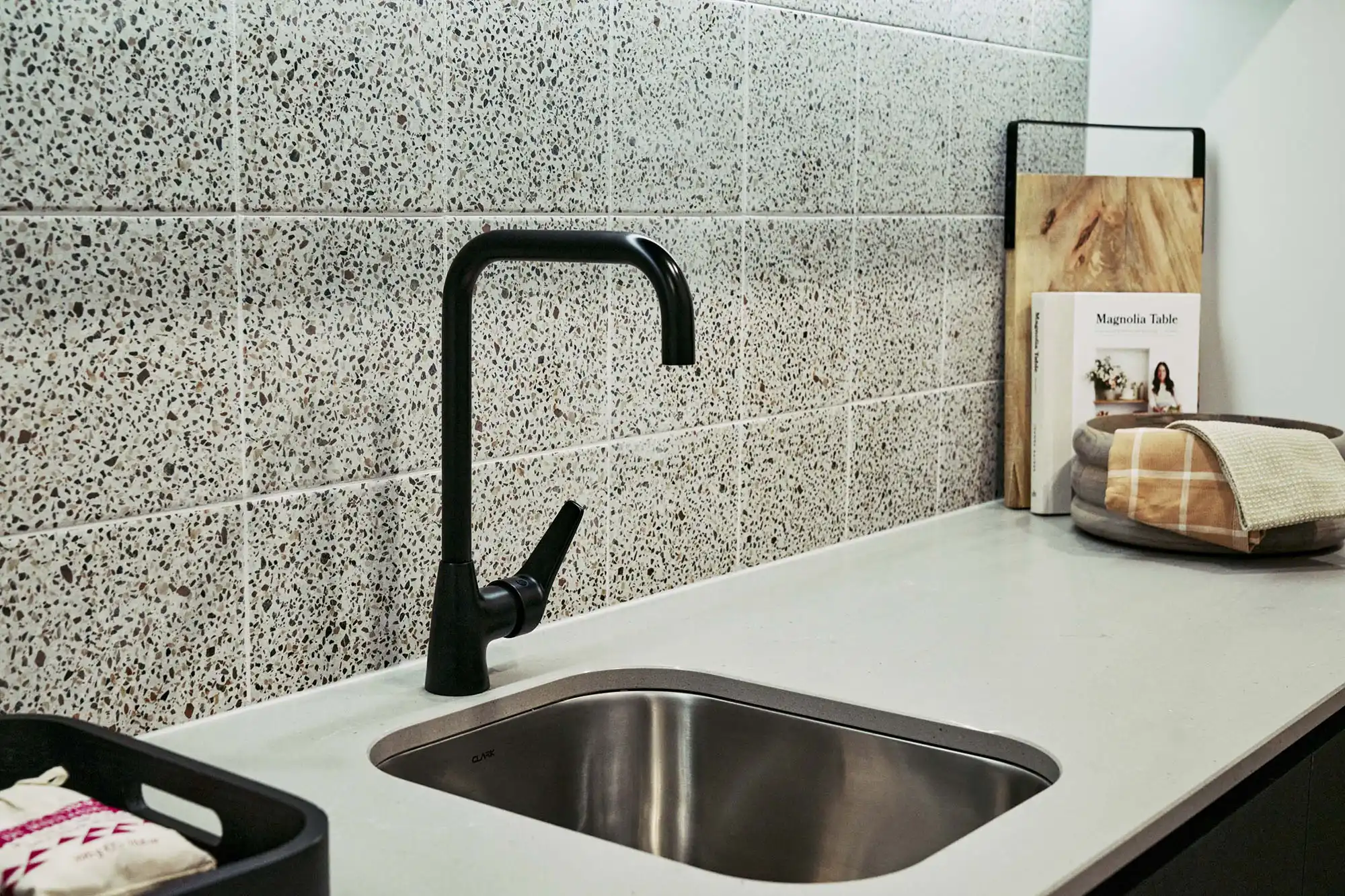 stone tiled splash back with matte black faucet in laundry at the armidale 37