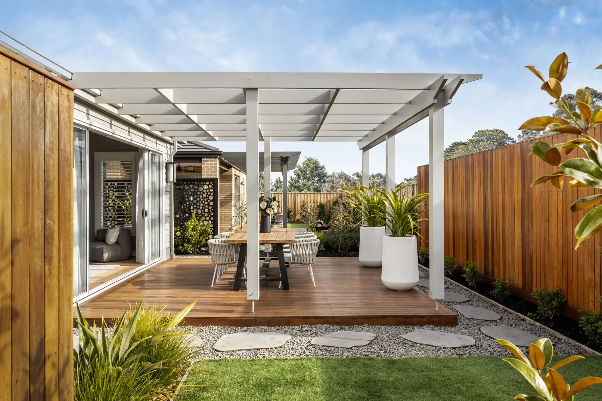 designing a outdoor space for a country home featuring stone steps timber decking and metal fence panels at the akuna 29