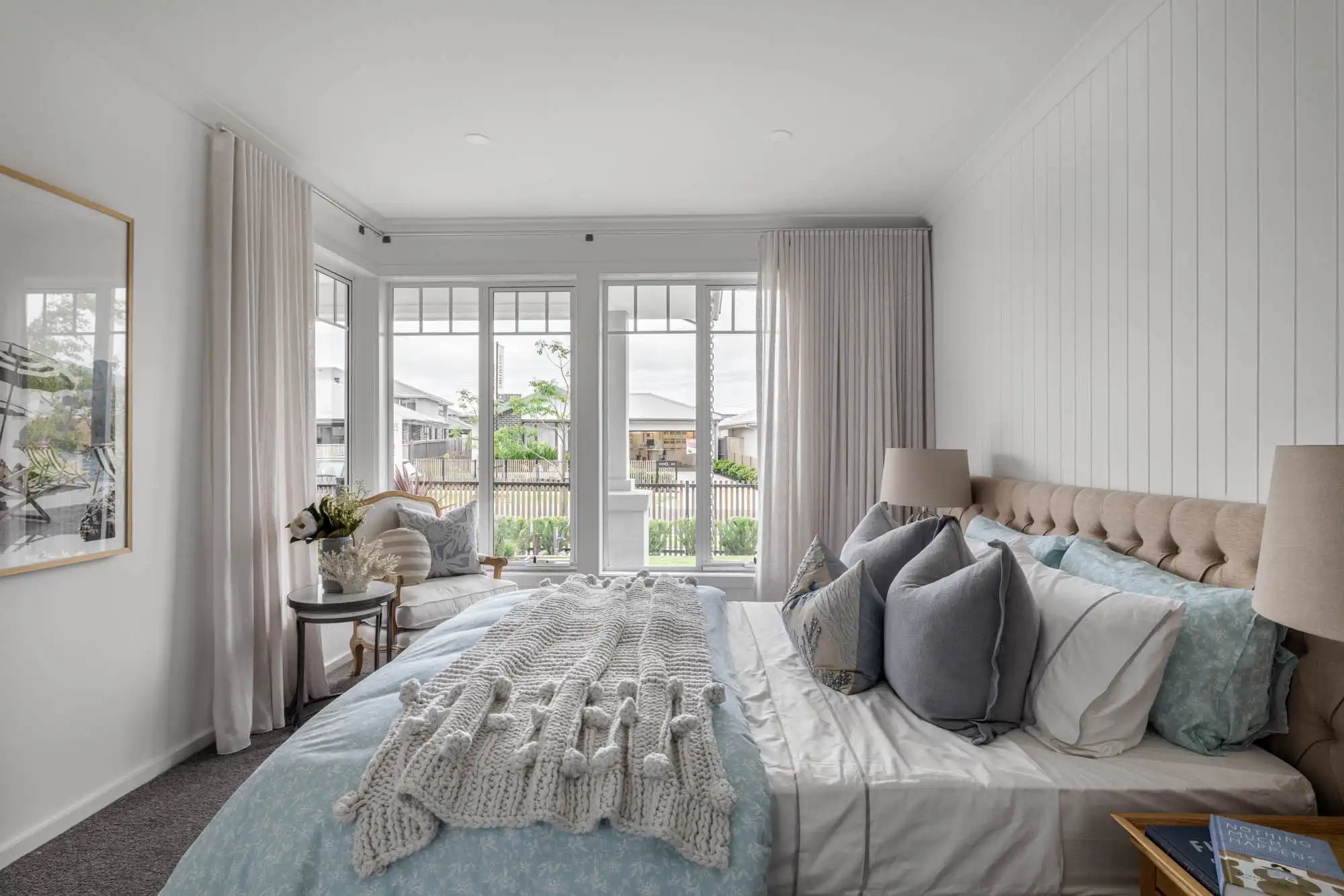 coastal master bedroom with cladding and floor to ceiling curtains with a corner window view at granite 23