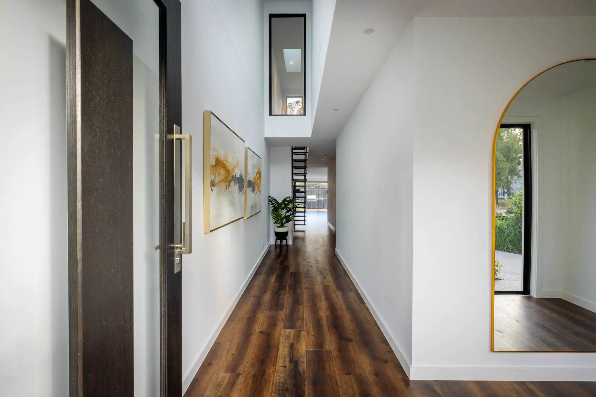 Interior photo of a hallway with wooden floors and a large mirror as a part of Masterpiece Milford home design.