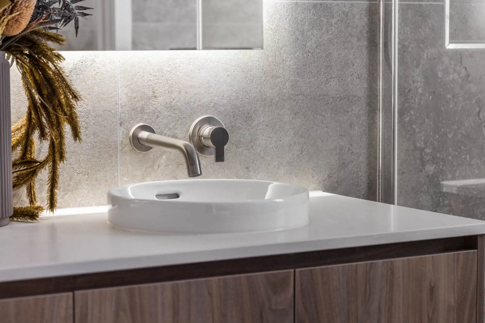 stone tiles in master ensuite with timber cabinet and chrome faucet at nowra 26