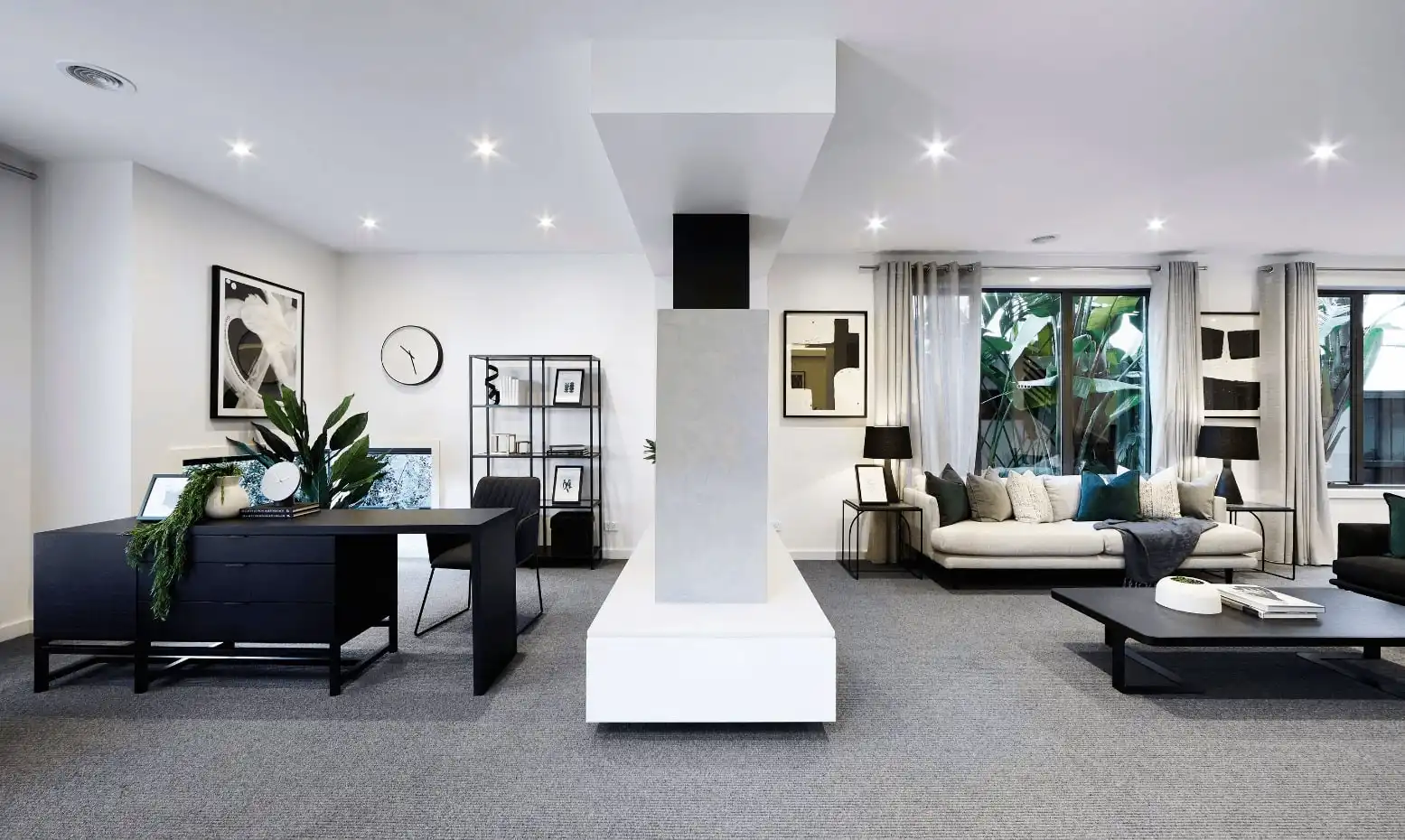 Study area separate from the living area with monochromatic tones throughout the open space