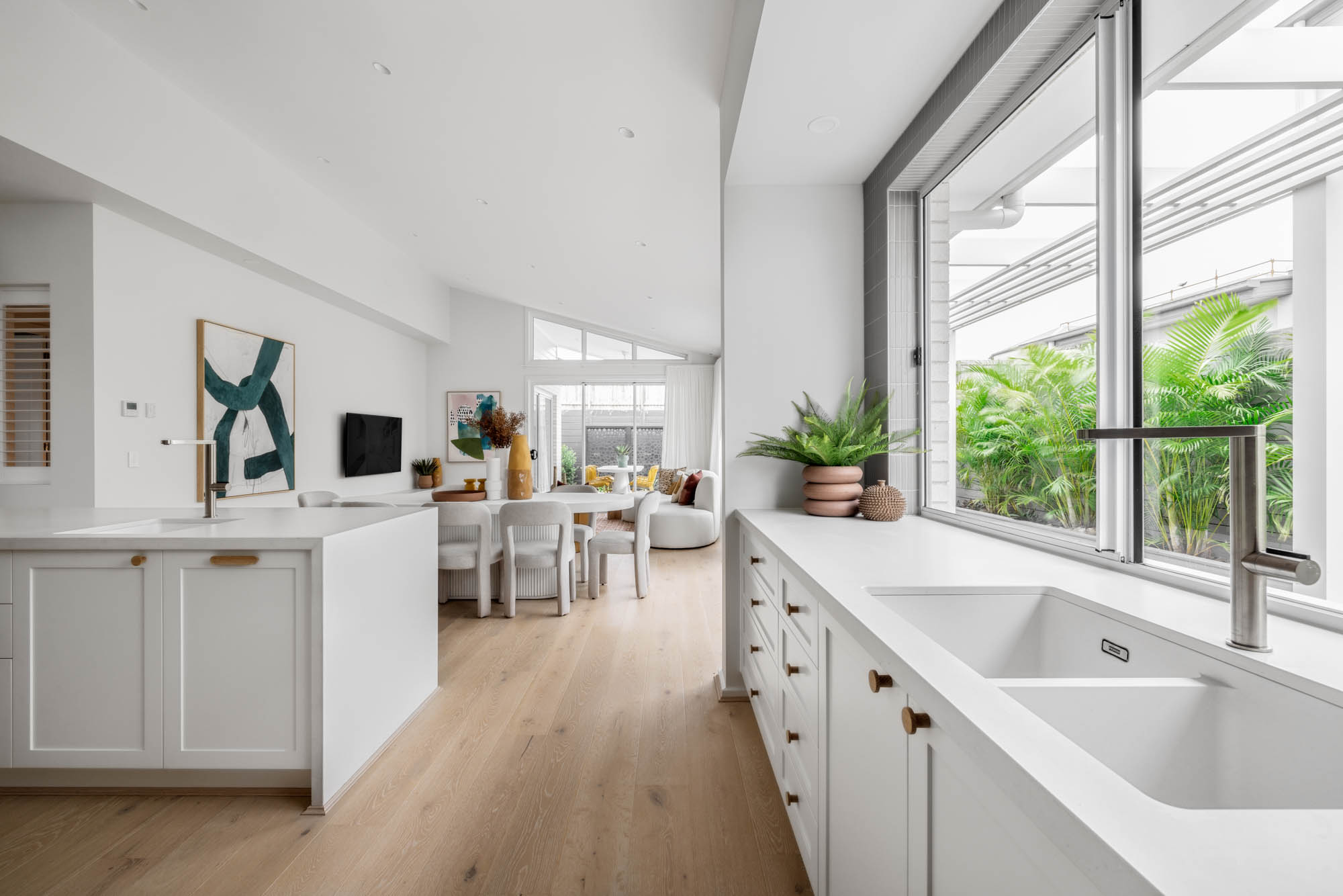 raised ceilings in this open living kitchen with white cabinetry and countertops brightens the space up at jervis 25