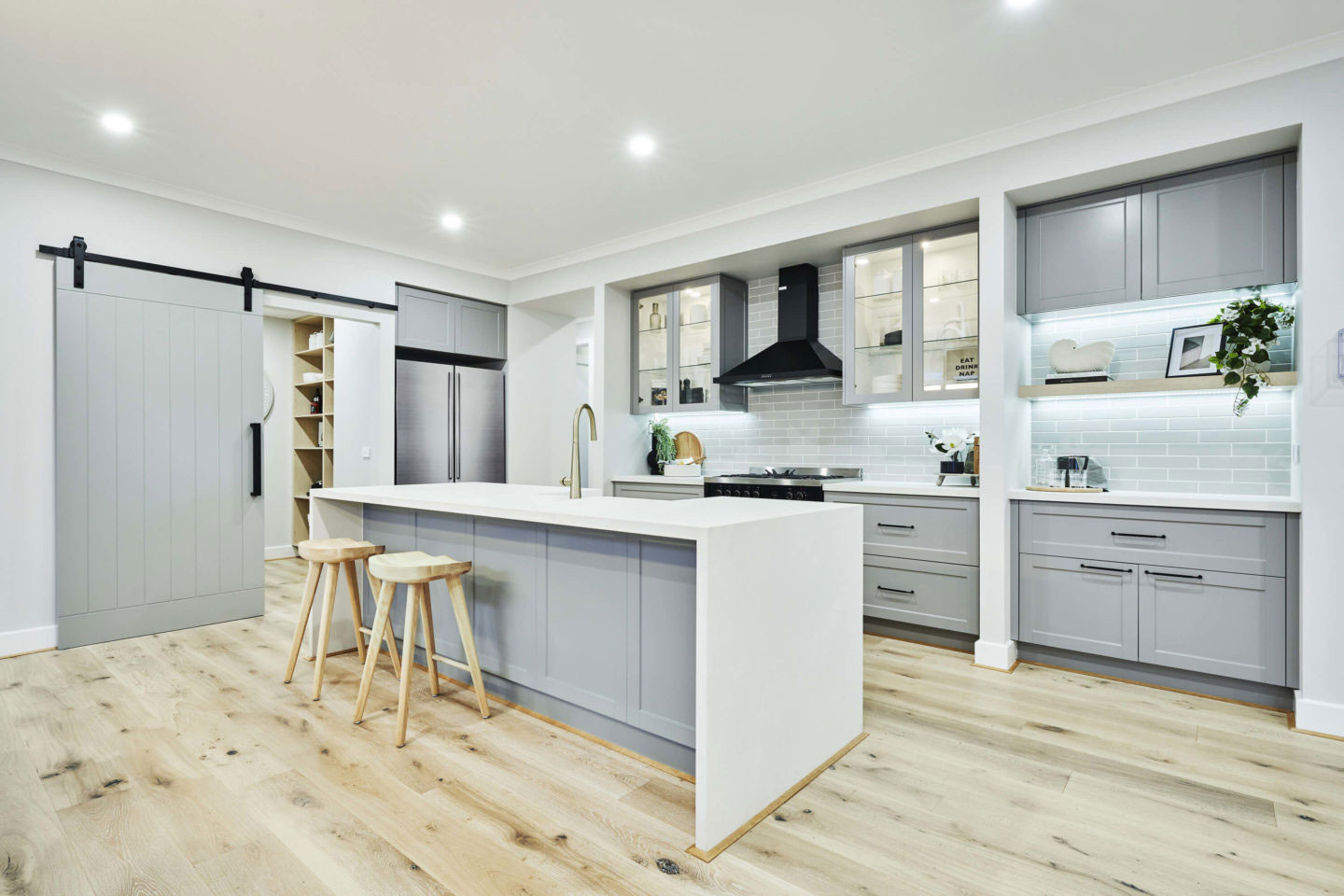 huge farm door blends the rustic charm and inviting atmosphere of this kitchen at akuna 29