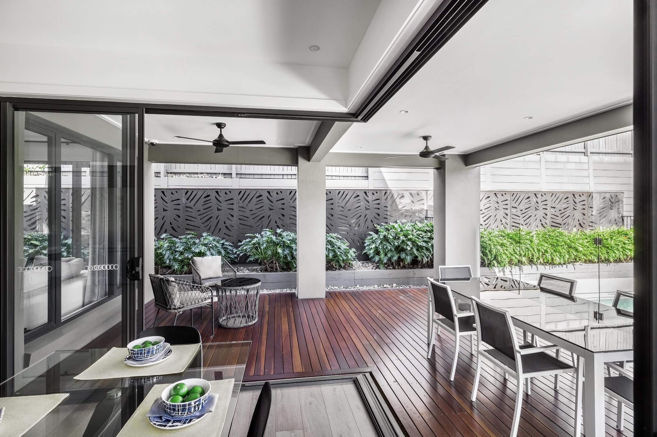 open living and kitchen with bifold doors opening up to the alfresco with timber decking surrounded at colston 26