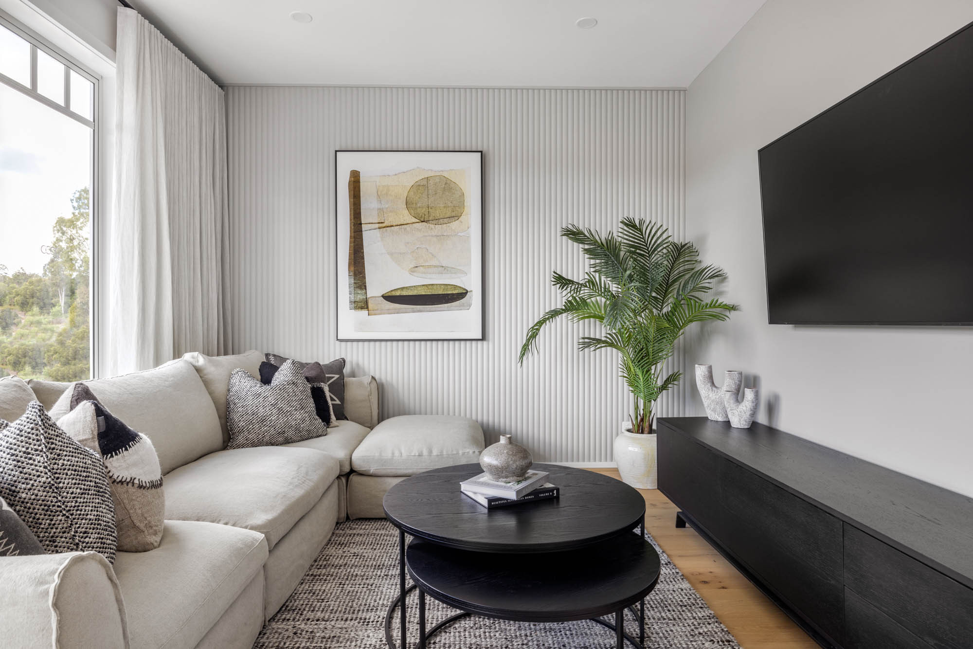 Comfortable living with wooden cladding as a featured wall with indoor plants to brighten up the space at riverway 26