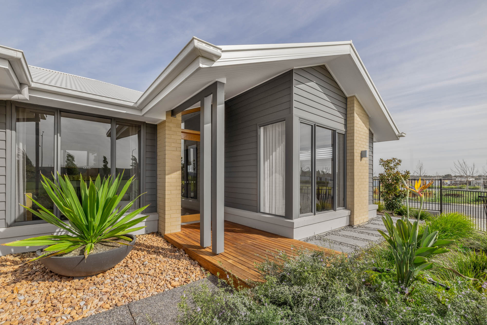 An exterior image of single storey home with long sliding windows and a front yard as part of Simonds Hampstead 32 home design.