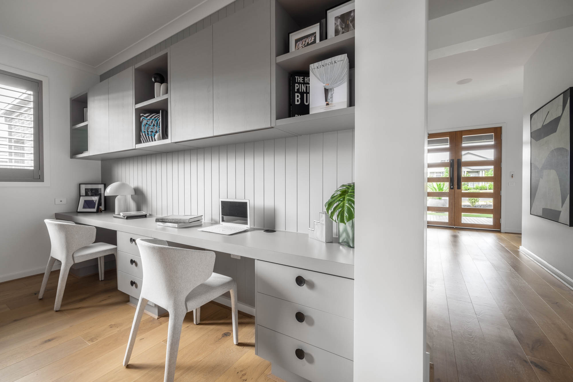 An interior image of an open plan with a study area and hallway with wooden flooring as part of Simonds Berrima 28 home design.
