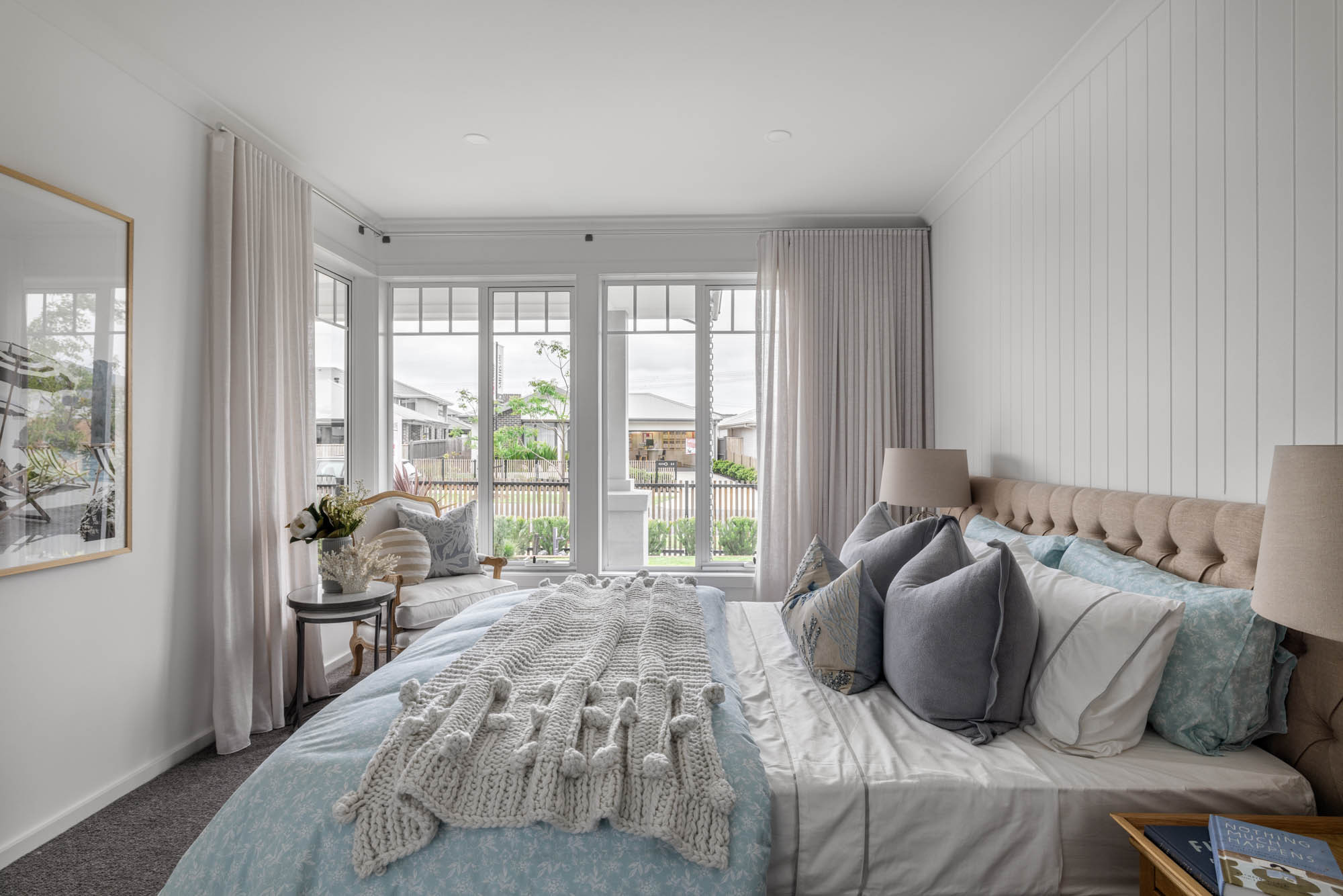 coastal master bedroom with cladding and floor to ceiling curtains with a corner window view at granite 23