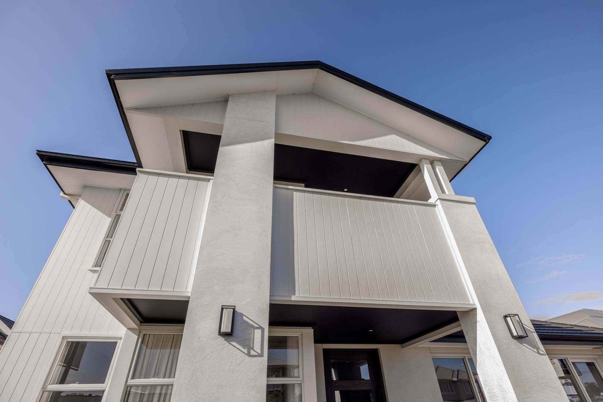 An exterior image of a modern double storey facade with a balcony as part of Simonds Tallowood 52 home design.